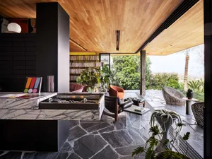 Marble-covered modern living room featuring contemporary furniture, indoor plants, and a large, open space.