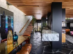 A modern lounge area with a marble countertop and wooden elements.