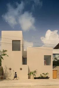 A minimalist house with a concrete exterior and large windows.