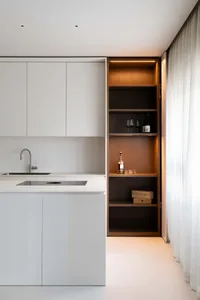 A modern minimalist kitchen with white cabinets and a sleek, contemporary design.