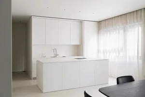 Modern kitchen with white concrete cabinets and minimalist design.