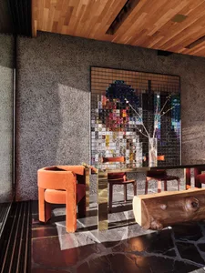 Modern interior design featuring metallic furniture and a mosaic tile wall with colorful square tiles.