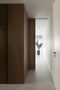 Modern interior design featuring a spacious hallway with concrete flooring.