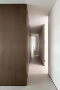A minimalist corridor featuring concrete and wooden walls.