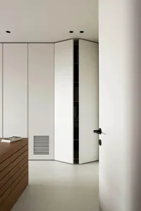 Modern interior of a white closet with wood accents and ventilation grille.
