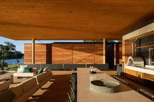 An outdoor residential patio featuring modern design elements and wooden surfaces.