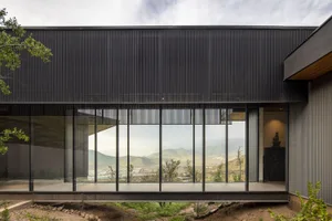 Modern house with large glass windows and black exterior cladding