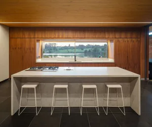 Modern kitchen with wooden cabinets, granite countertop, and a large window overlooking a scenic view.