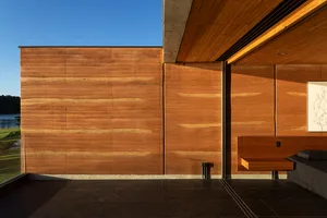 Modern residential interior featuring wooden walls, concrete flooring, and a minimalistic design.