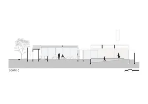 Modern bus stop with glass walls and an outdoor seating area.