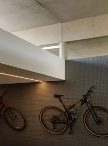 Bike storage area with bicycles mounted on the wall in a modern interior with concrete elements.