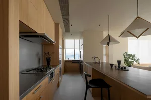 Contemporary kitchen with wooden cabinets, black countertops, and a large island.