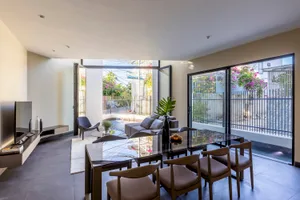 Modern living room featuring a glass slider leading to an outdoor area with a pool and garden.