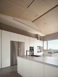 A modern minimalist kitchen featuring white cabinetry and stainless steel appliances.