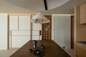 A modern minimalist kitchen featuring wooden cabinets and metal accents.