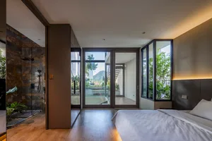 A modern residential interior with glass, wood, and stone materials.