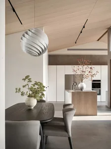 Modern residential kitchen featuring a sleek, minimalist design with white wood furnishings and white kitchen appliances.