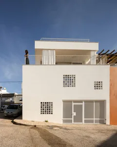 Modern building with white plaster exterior and glass windows.