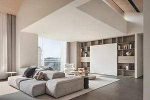 Modern minimalist living room featuring a comfortable sofa, white armchair, and a bookshelf