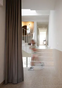 A modern hallway featuring concrete flooring and tiled steps.