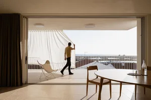 Man opening curtain in modern retail storefront with concrete finishes.