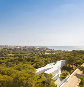 A minimalist residential building featuring white glass and a modern design.