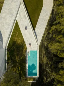 A modern, minimalist outdoor space featuring a concrete pool.