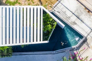 A modern house with a concrete roof and a rooftop garden with plants.