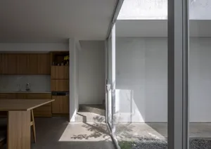 A minimalist kitchen with concrete walls and flooring.