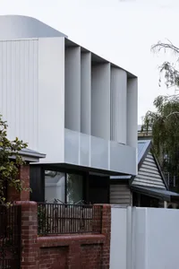 A modern building with metal paneling and large windows.