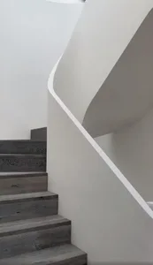 A modern staircase with wooden steps and a white rail.