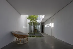 Modern residential interior with glass walls and concrete flooring
