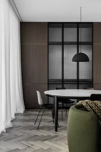 Minimalist dining room featuring a marble dining table, modern chairs, and a pendant light.