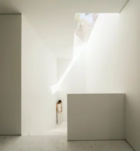 A minimalist interior space with a marble floor and concrete walls.