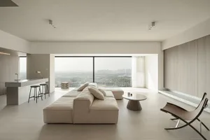 Modern minimalist living room with concrete elements and a panoramic view.