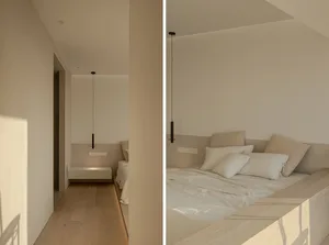 Minimalist bedroom with neutral tones featuring a bed with white bedding and pillows, hanging pendant lights, and a Floating