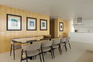 Modern dining room with glass table and wooden accents.