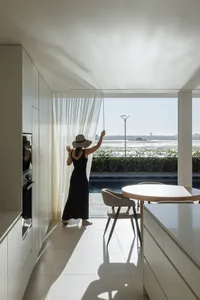 A modern interior space with glass walls and a view of the water.