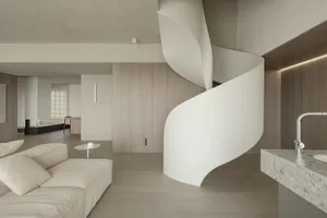 A modern living space featuring neutral-toned walls, flooring, and furniture.