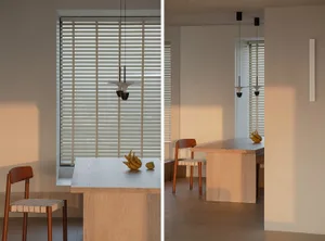 Minimalist dining room with wooden table, glass window, and blinds
