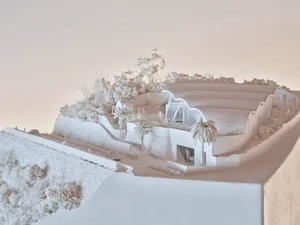 A detailed plaster-cast concrete architectural model depicting a modern residential structure with landscaped surroundings an