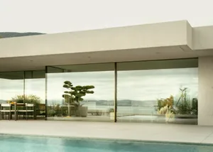 A modern minimalist house with extensive glass and concrete features.