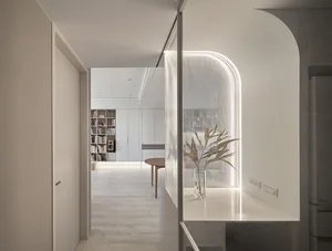 Modern minimalist residential interior with white stone elements and sleek white design.