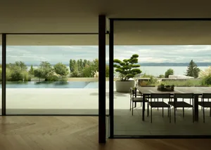 Modern residential interior with wooden flooring and concrete elements, featuring a dining area by a poolside and outdoor sea