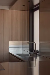 Modern minimalist kitchen featuring wooden finishes and sleek, minimalist design elements.