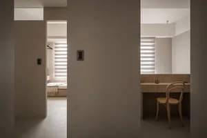 A minimalist bedroom with neutral tones and modern furniture.
