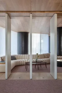 A modern living room with a curved sofa and textured cushions.