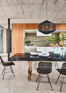 An industrial style residential kitchen with wood features including a rustic wood dining table, black woven basket chandelie