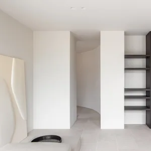 A minimalist interior space featuring concrete flooring and modern architectural elements.