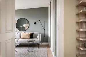Modern minimalist living room with gray sofa, black and white scandinavian floor lamp, and minimalist coffee table.